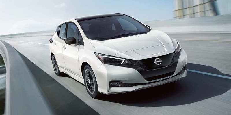 front right angle of a white 2024 nissan leaf driving on an overpass