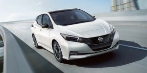 White 2024 Nissan Leaf driving down a street