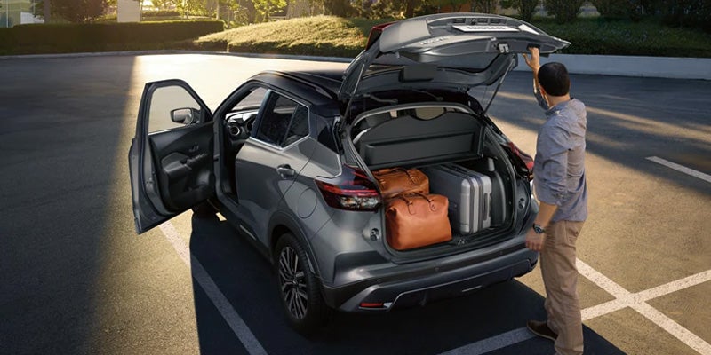 man packing up the cargo space on the 2024 nissan kicks