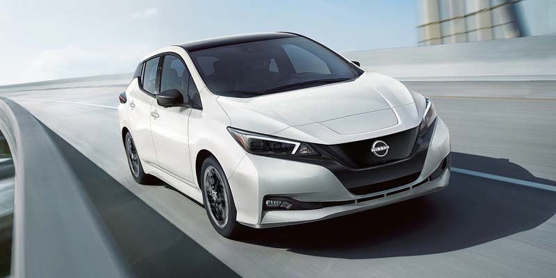 front right angle of a white 2024 nissan leaf driving on an overpass