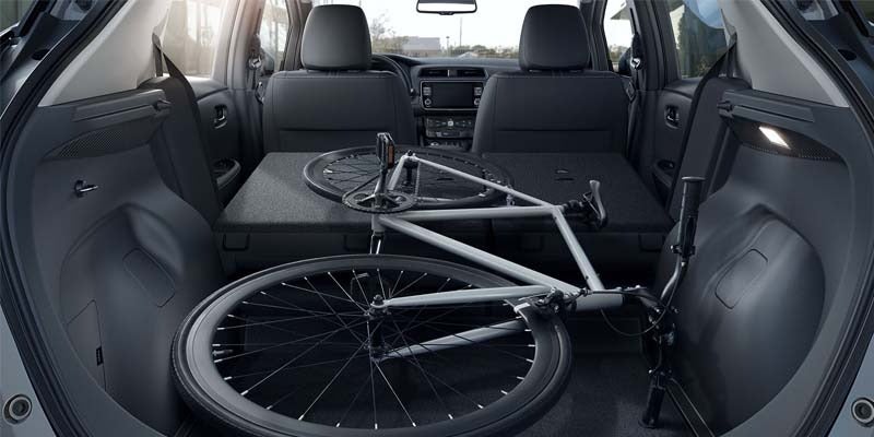 view of the interior of a 2024 nissan leaf with backseats folded down to fit a bicycle
